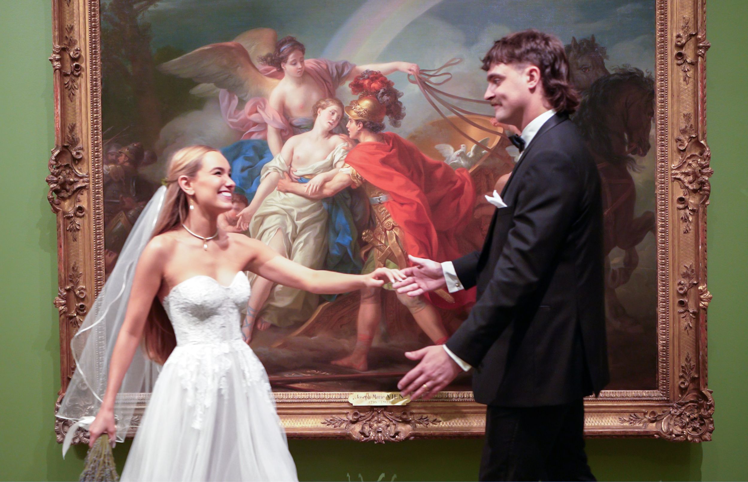 A couple in wedding attire shares a joyful moment in Columbus Museum Of Art
