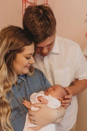 A touching family moment in a nursery with a newborn baby.