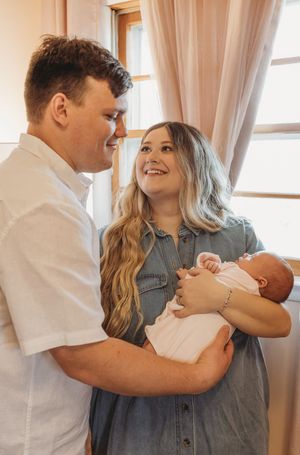 A joyful moment shared in a sunlit nursery room with sheer curtains.