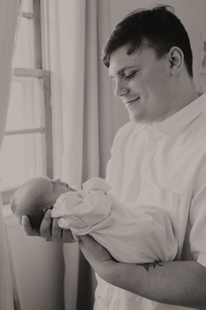 Gentle black and white portrait of a tender moment with a newborn.