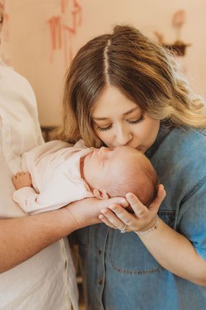 Close-up of parents sharing an intimate moment with their newborn baby.