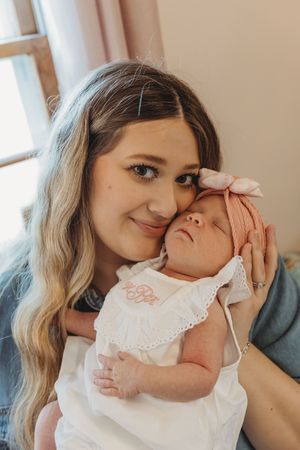 Sweet candid photos showing loving interactions with an infant in white lace clothing.