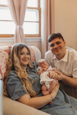 Family photo series showing parents sharing joyful moments with their newborn on a couch.
