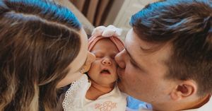 Sweet newborn photography session showing gentle moments between parent and baby.
