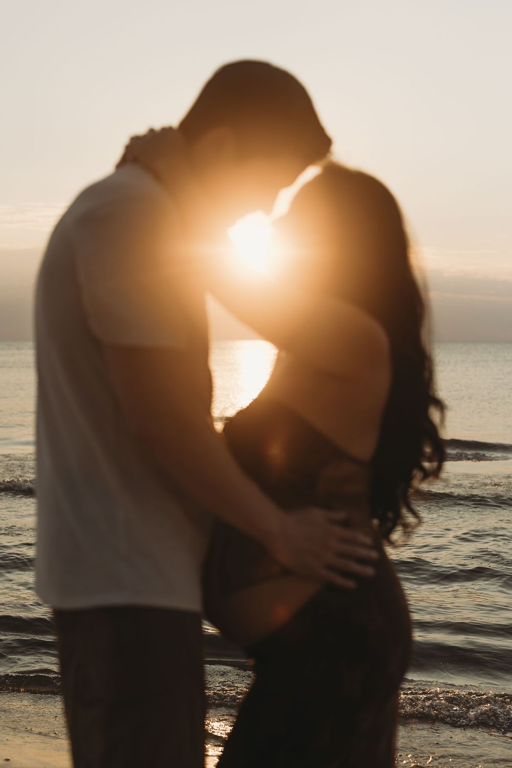 Silhouetted couple embraces on beach at sunset with golden light creating romantic atmosphere across multiple frames.