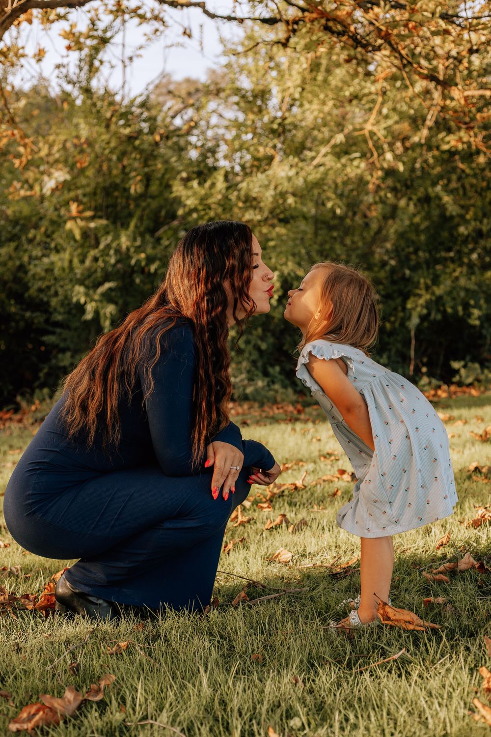 Candid series of playful moments between parent and child sitting in grass during golden hour sunset.