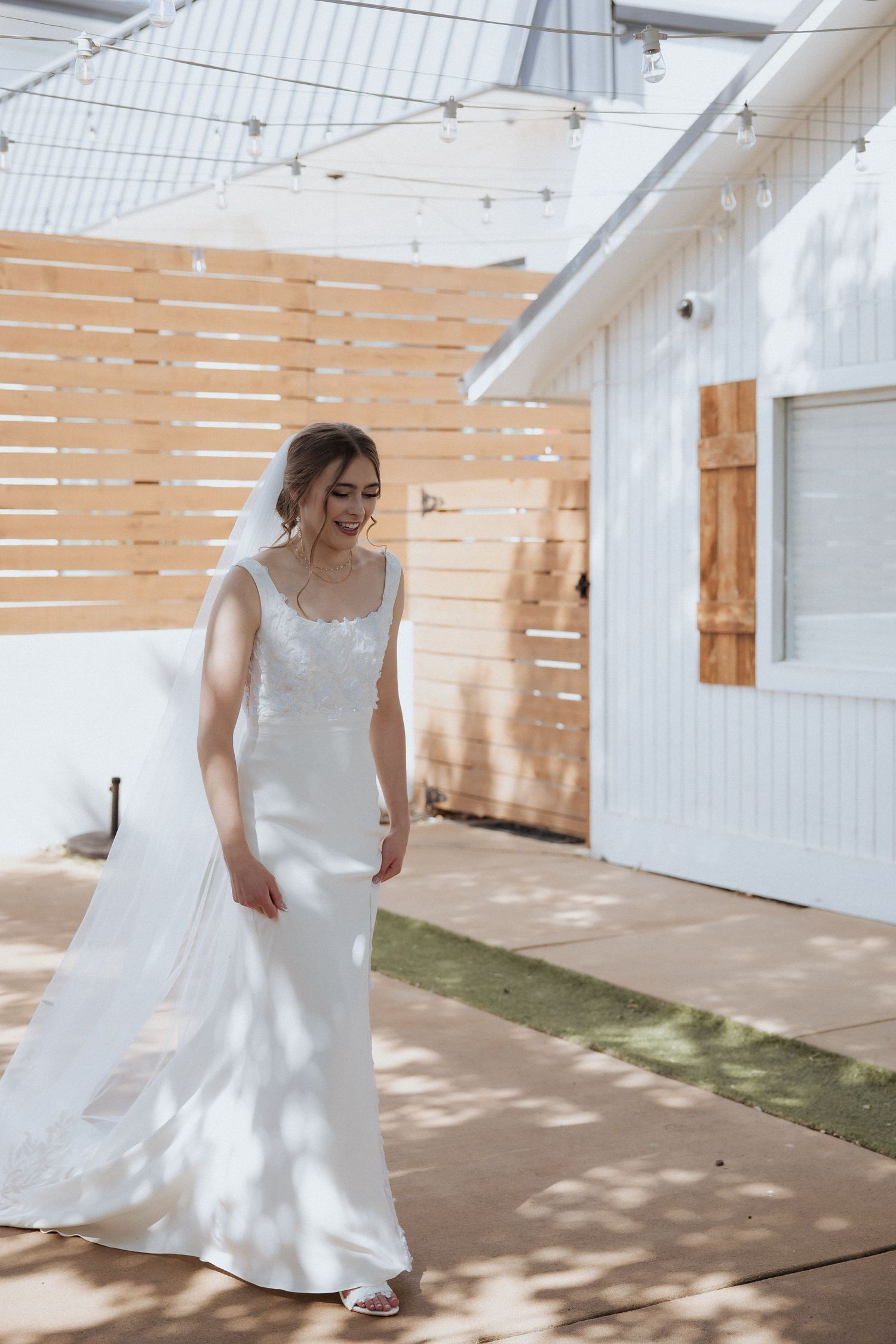 A series of five photos showing a person in a flowing white dress twirling and dancing in a bright indoor space.