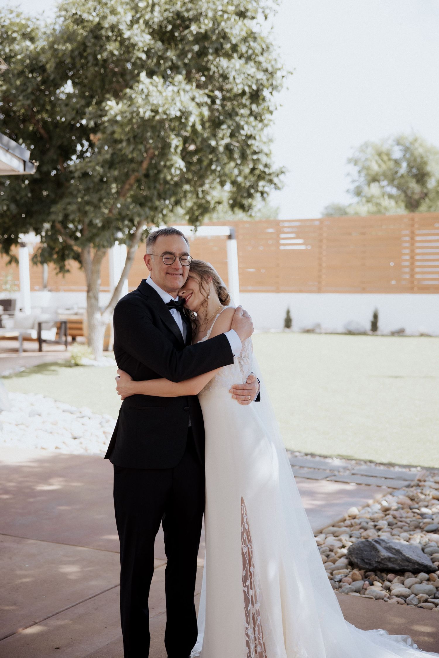 A sweet first look moment between a bride and groom hugging outdoors at their wedding ceremony.