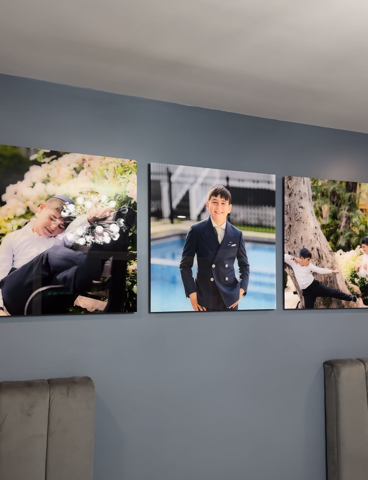 Row of wedding photographs displayed on gray wall in modern interior setting.