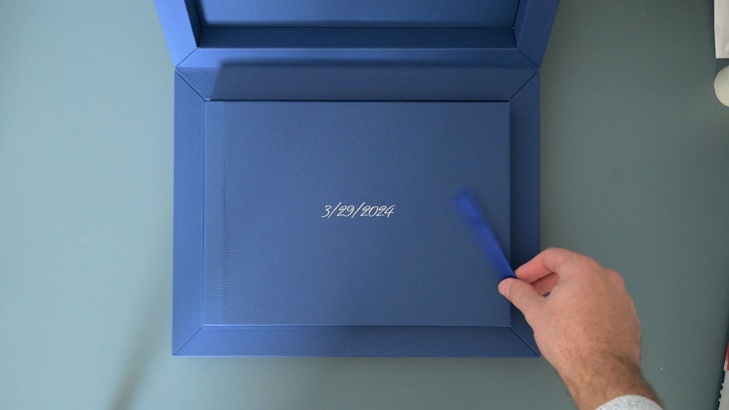 Series of hands adjusting blue panels on a light colored wall.
