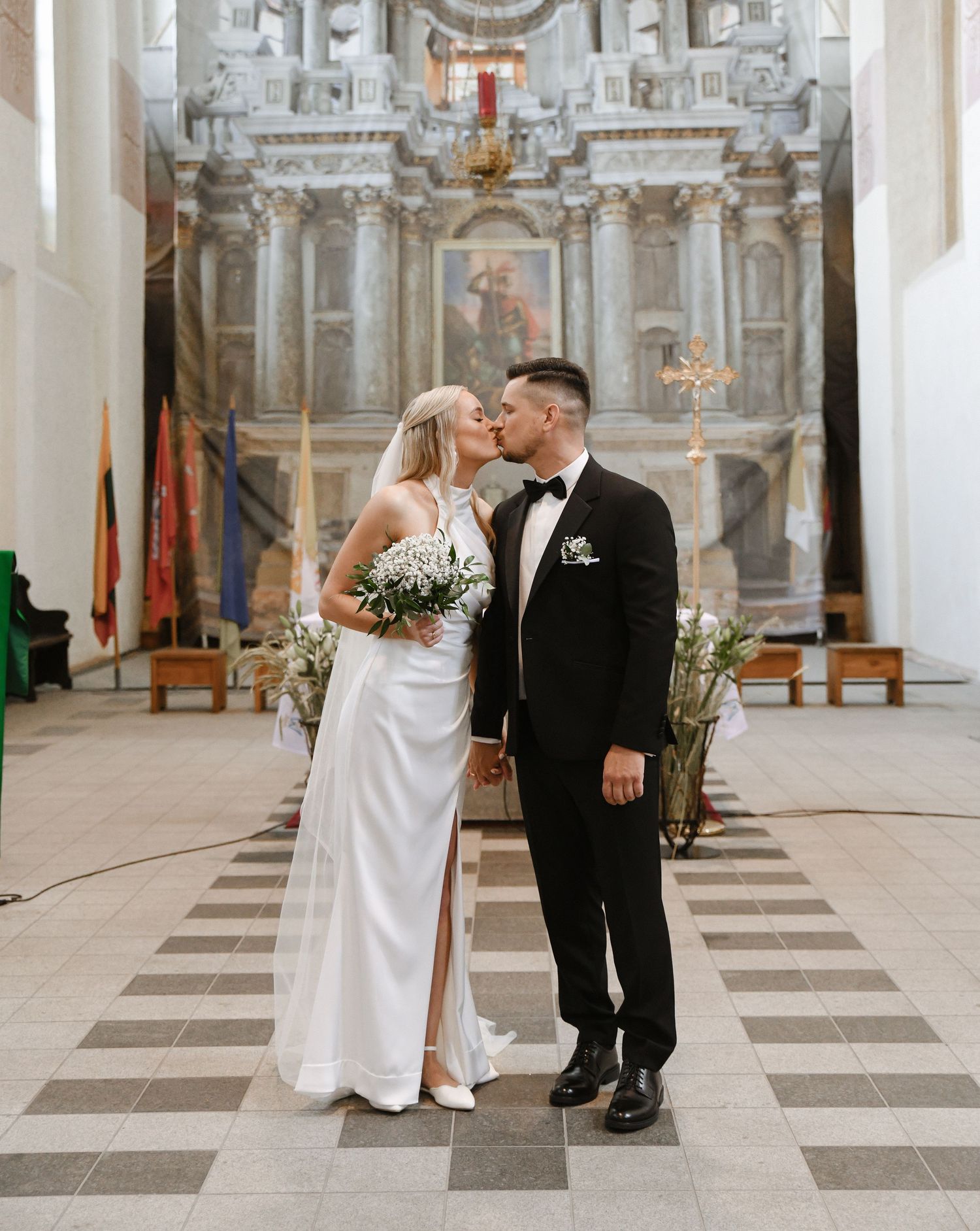 Wedding couple shares intimate moments in an ornate church interior with classical architecture and marble floors.