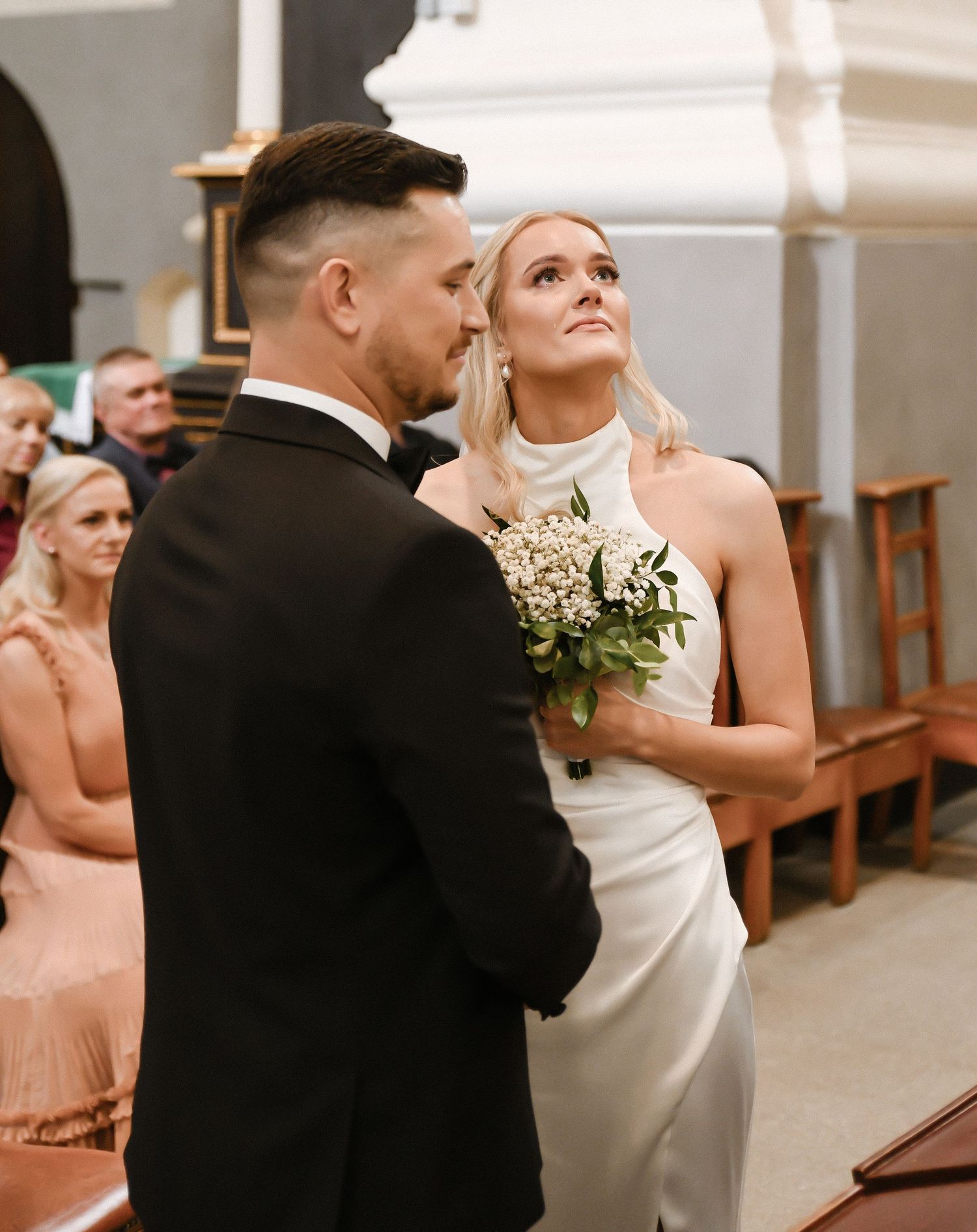 Newlyweds dance together during their first dance in an elegant indoor venue.
