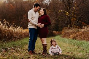 A romantic outdoor fall photo session with warm autumn colors and natural foliage in the background.