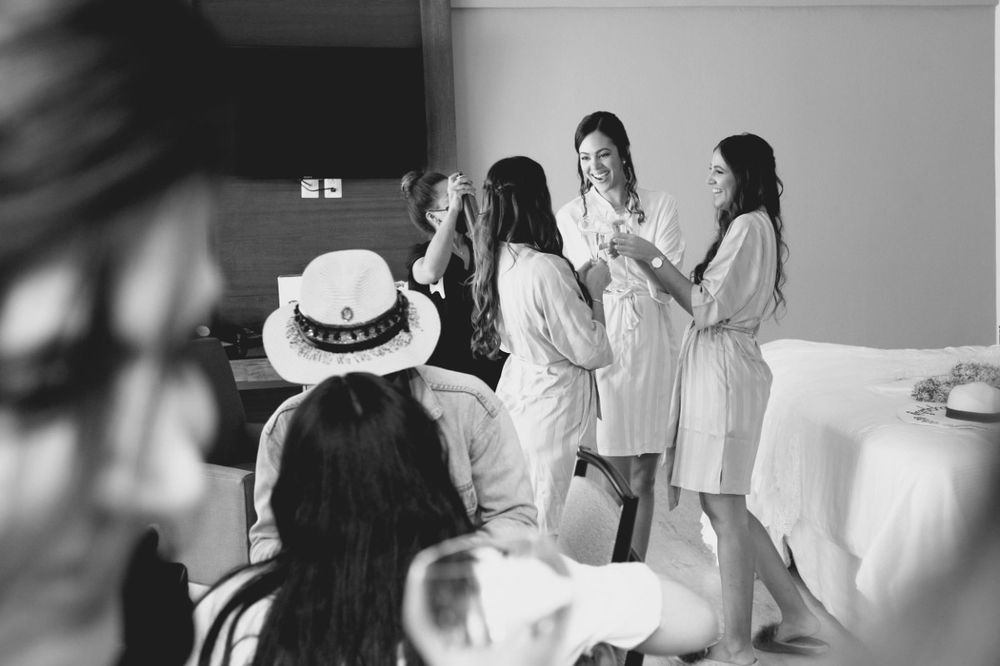 Black and white photos showing wedding preparations with people getting ready in formal attire.