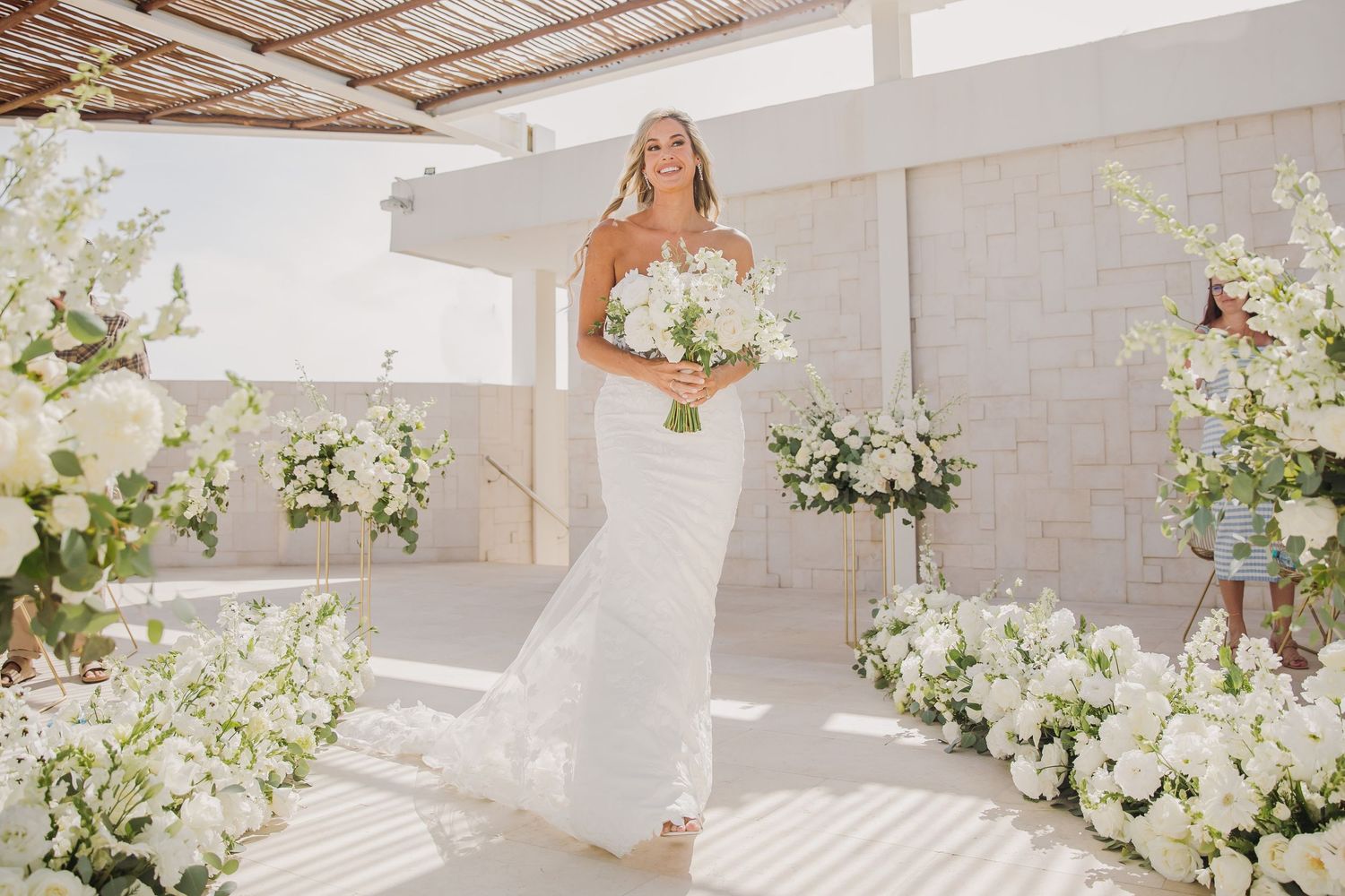 White floral arrangements and decor in a bright, modern wedding ceremony space. Dreams Sapphire Riviera Maya Wedding Photography