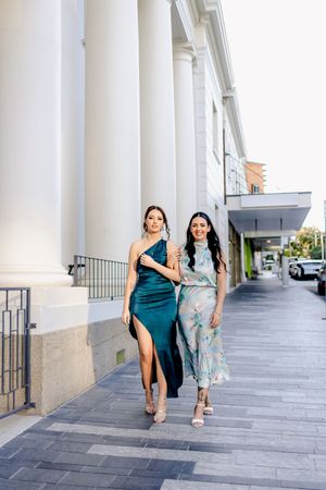 A sequence of poses along a covered walkway with white columns.