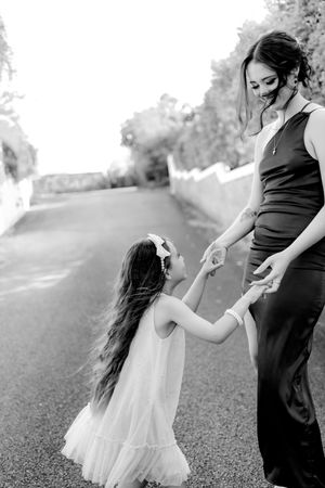 A touching black and white moment captured on a path as two figures hold hands while dancing.