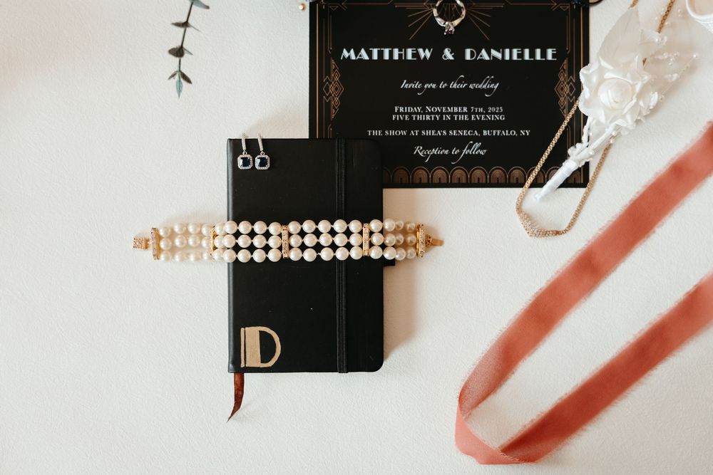 Elegant black and rose gold wedding invitation suite with delicate calligraphy and decorative details.