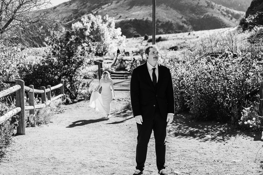 A black and white photo series shows a couple walking together outdoors in a natural mountain setting.