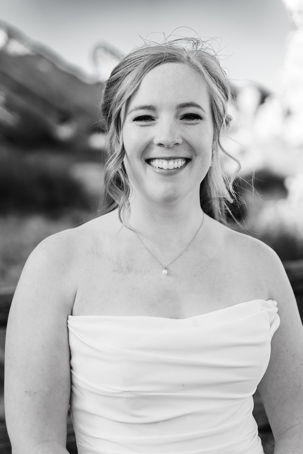 A sequence of black and white close-up portraits showing joyful expressions in a strapless white dress.