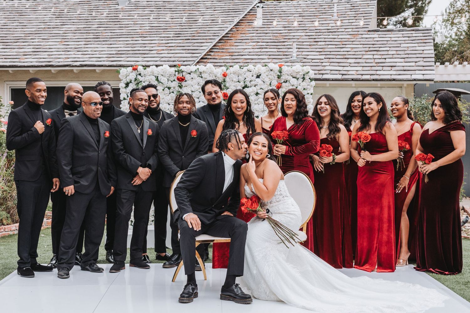 Wedding party members dance together in a line during a reception celebration on a dance floor.