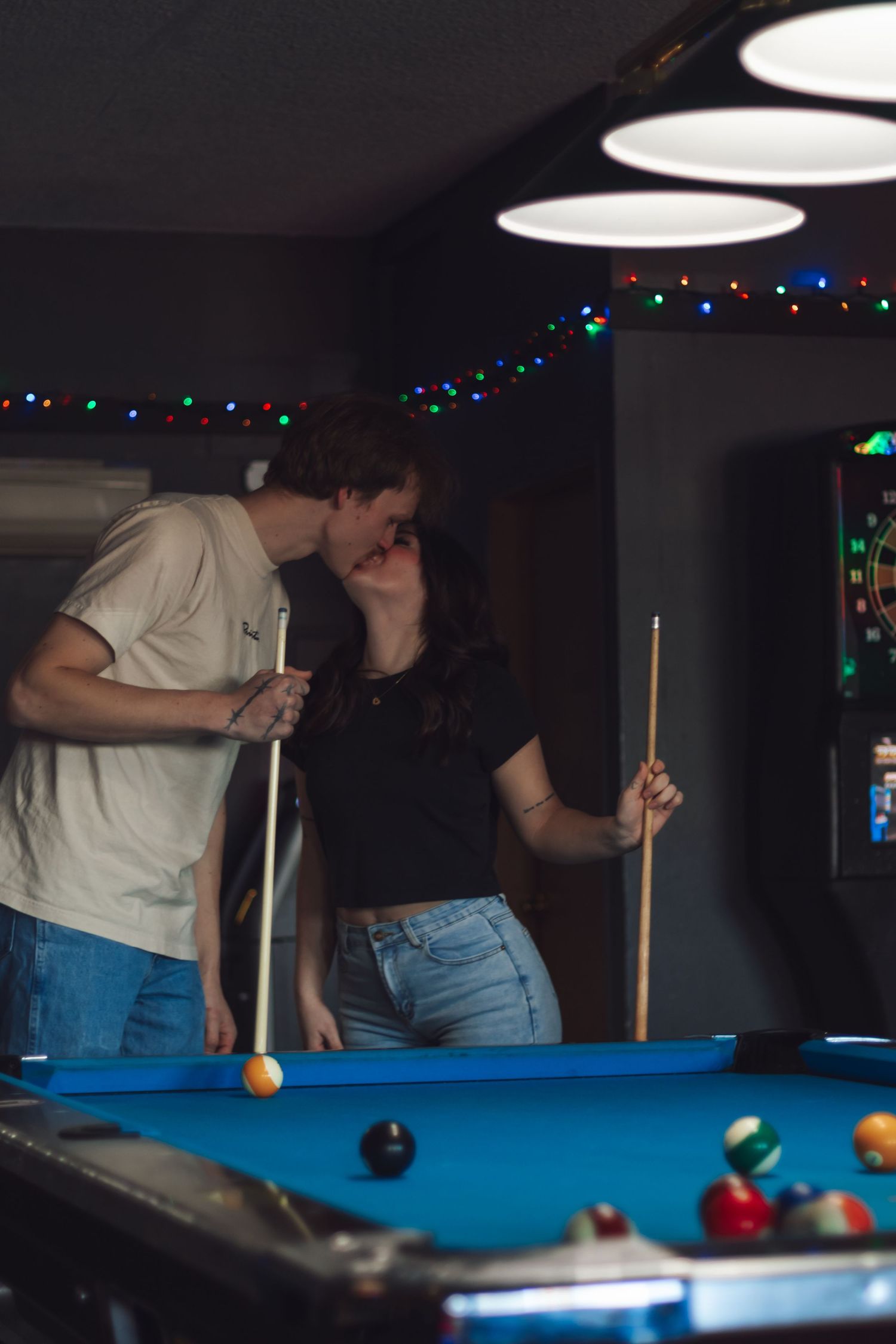 couple kissing by pool table at tommys tavern in a yelm washington dive bar photoshoot by pierce county photographer