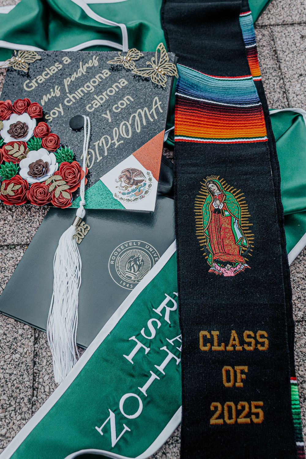 Decorated graduation stoles featuring religious and cultural designs in green and black.