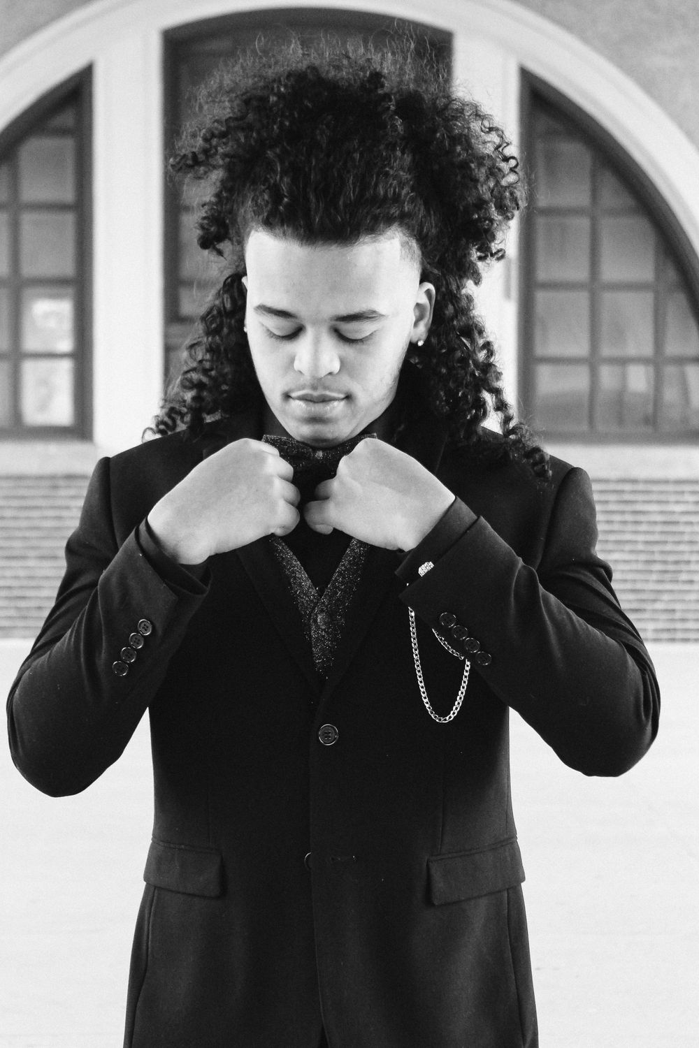 Artistic black and white portrait sequence showing different poses with curly hair.