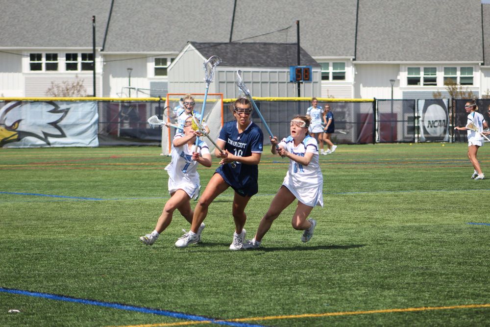 Lacrosse players battle for ball possession during intense field play.