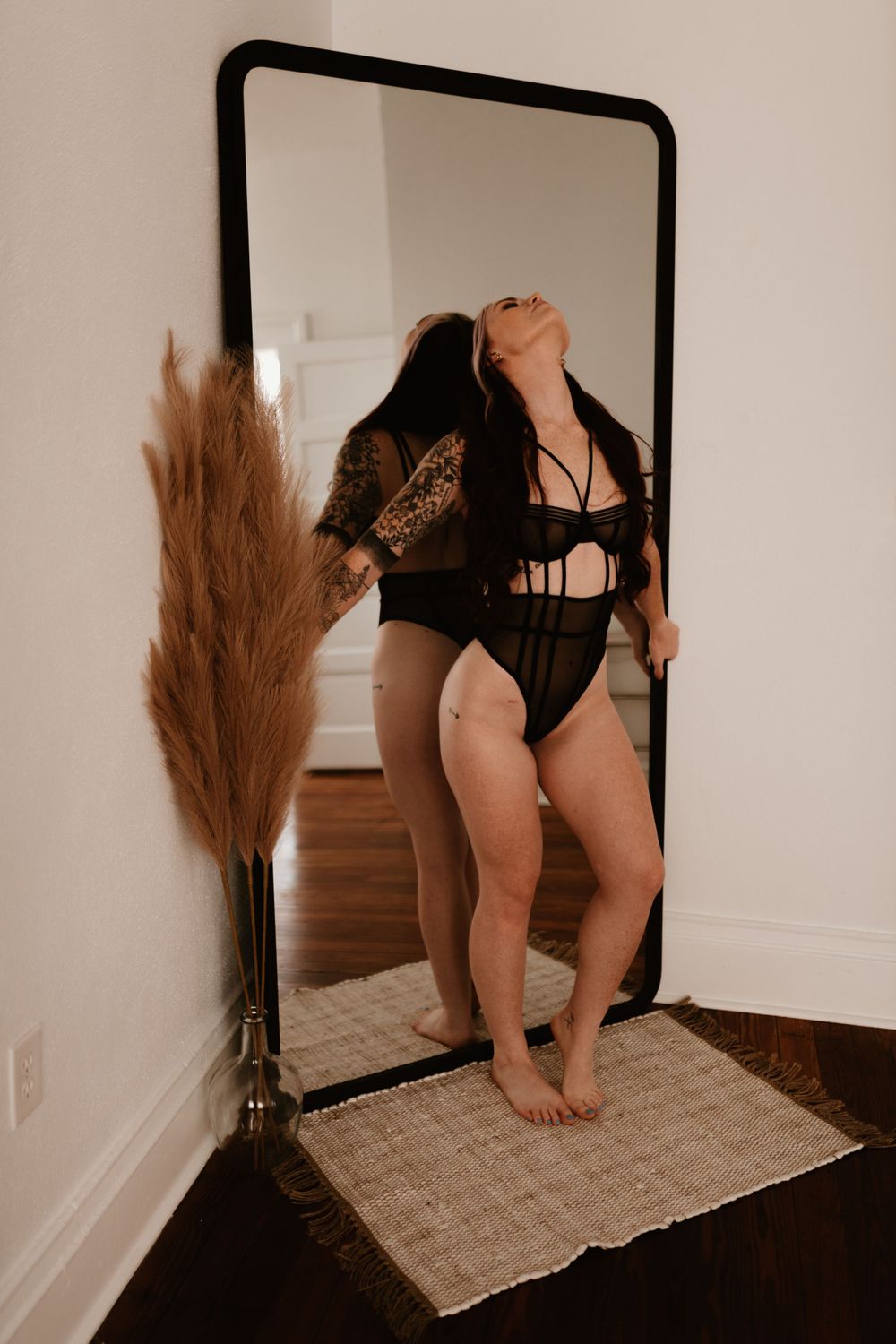 Mirror selfie with pampas grass decor and natural lighting.