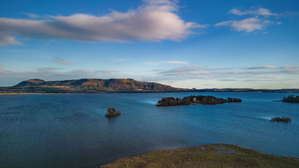 Coastal panorama showing blue ocean waters, cliffs and islands under bright summer sky.