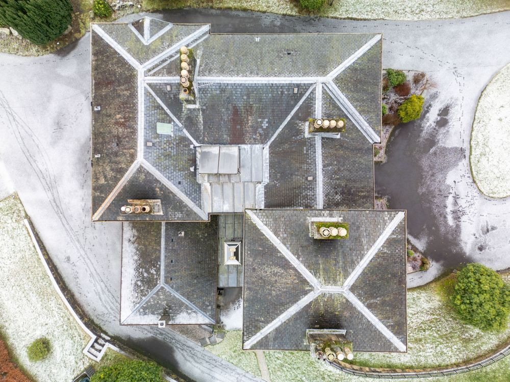 Drone shot of gray rooftops and buildings from directly above.