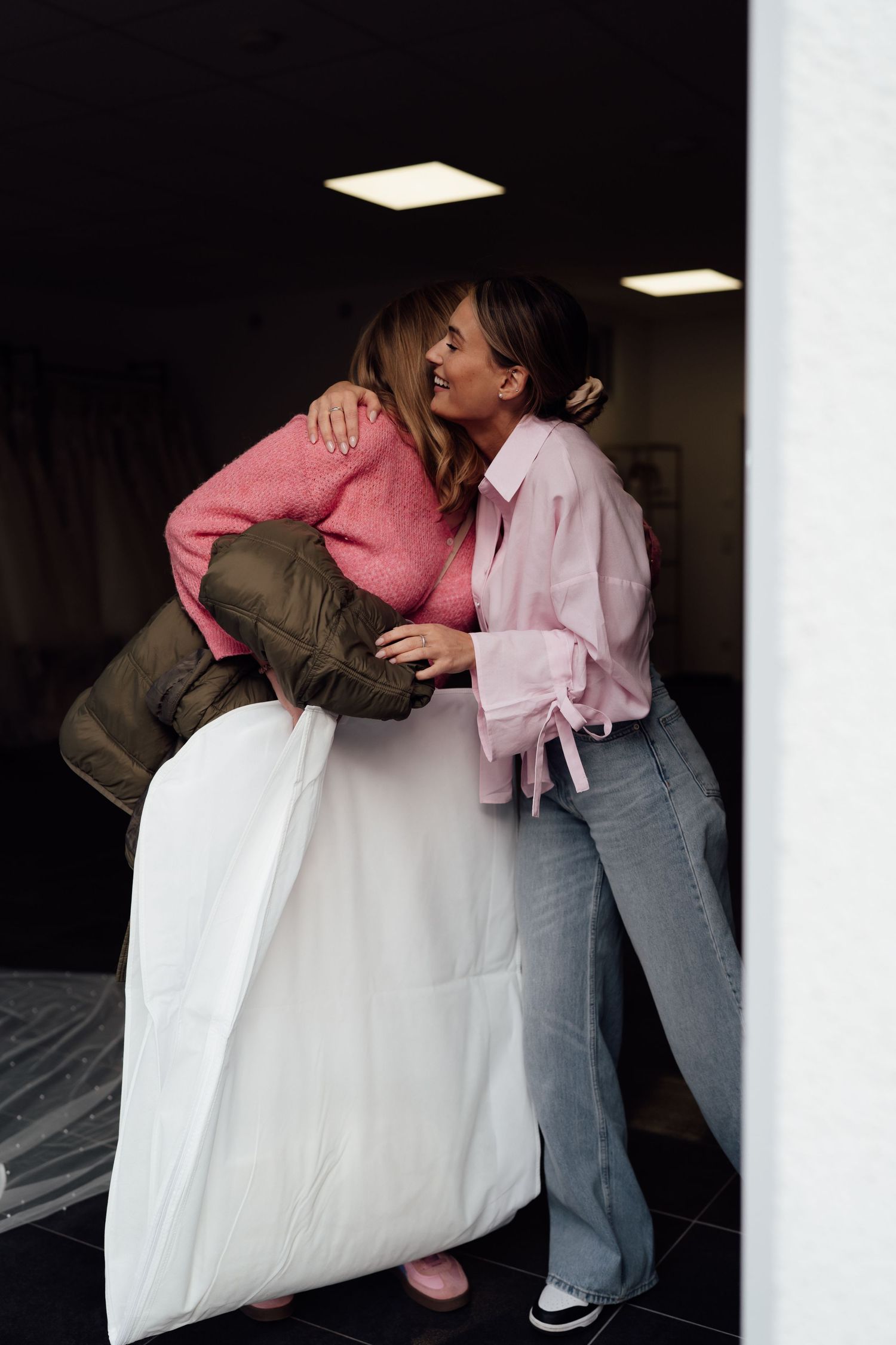 Eine Kundin wird glücklich mit ihrem Brautkleid verabschiedet. Coffee and Stories Fotografie