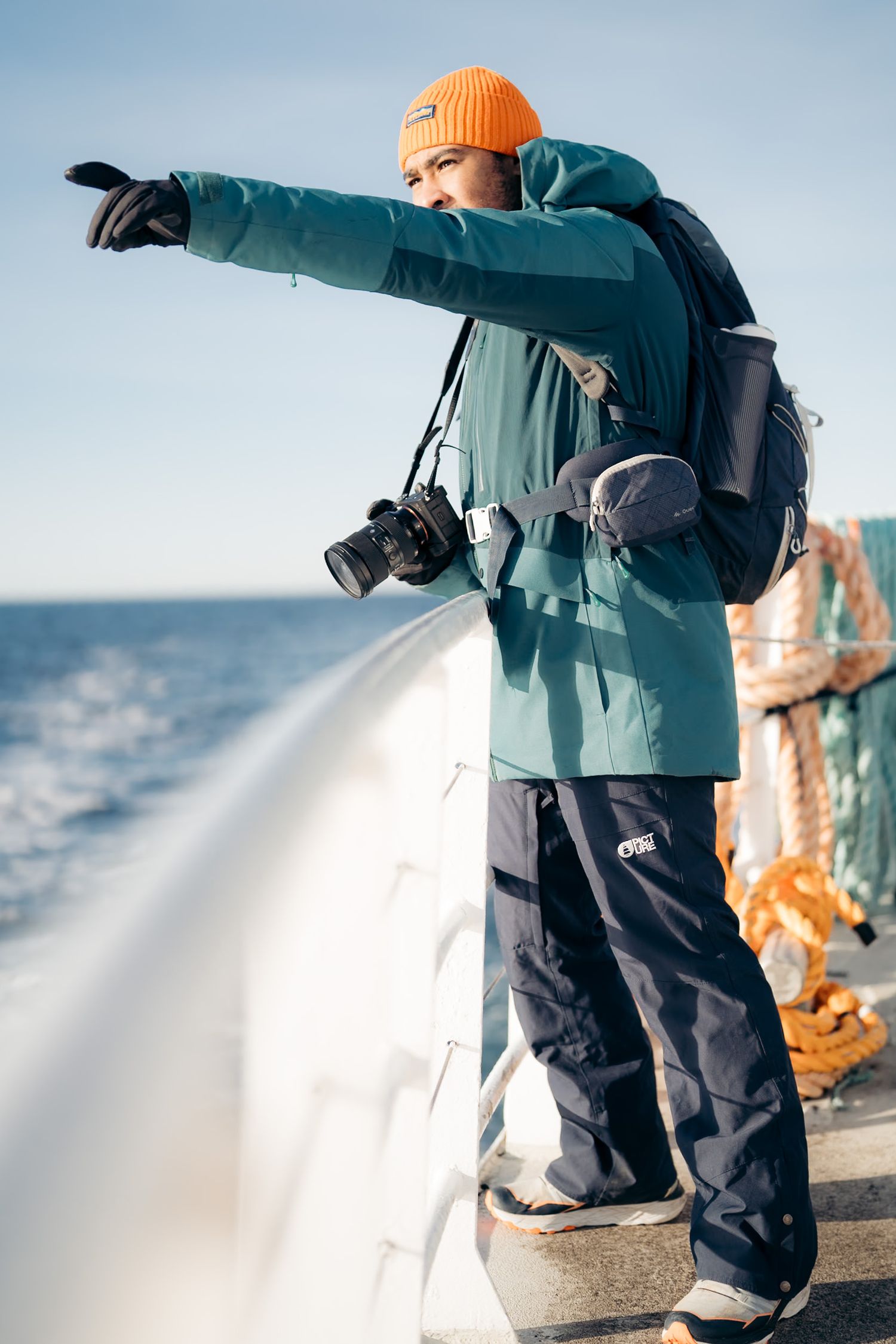 Homme qui fait une excursion baleines en Norvège sur un bateau qui pointe du doigt