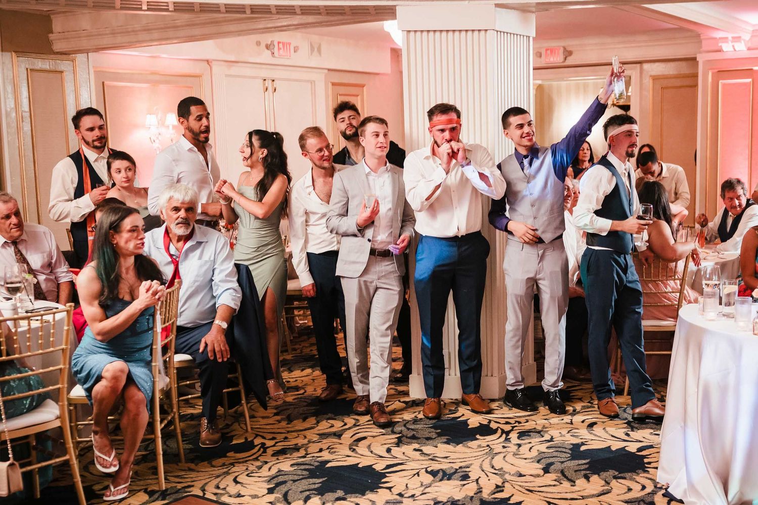 Wedding guests cheering and celebrating during the cake cutting moment at a Lenox Hotel Boston reception
