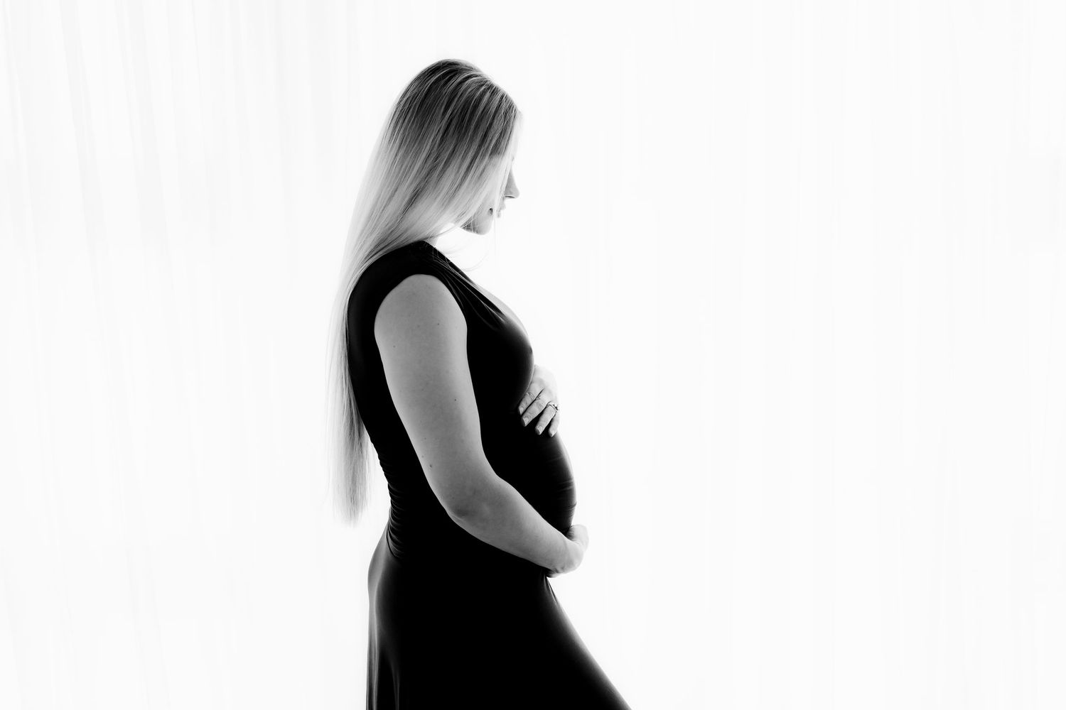 Artistic silhouette series showing stages of pregnancy against white background.