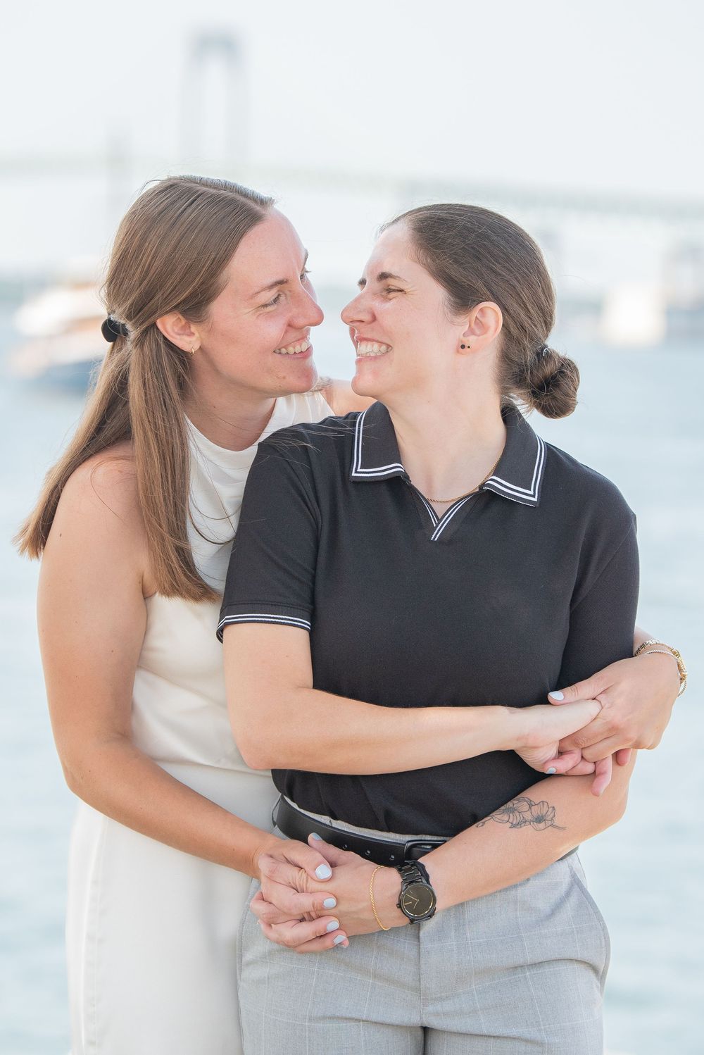 A couple shares joyful moments together in a series of candid seaside photos wearing light and dark outfits.