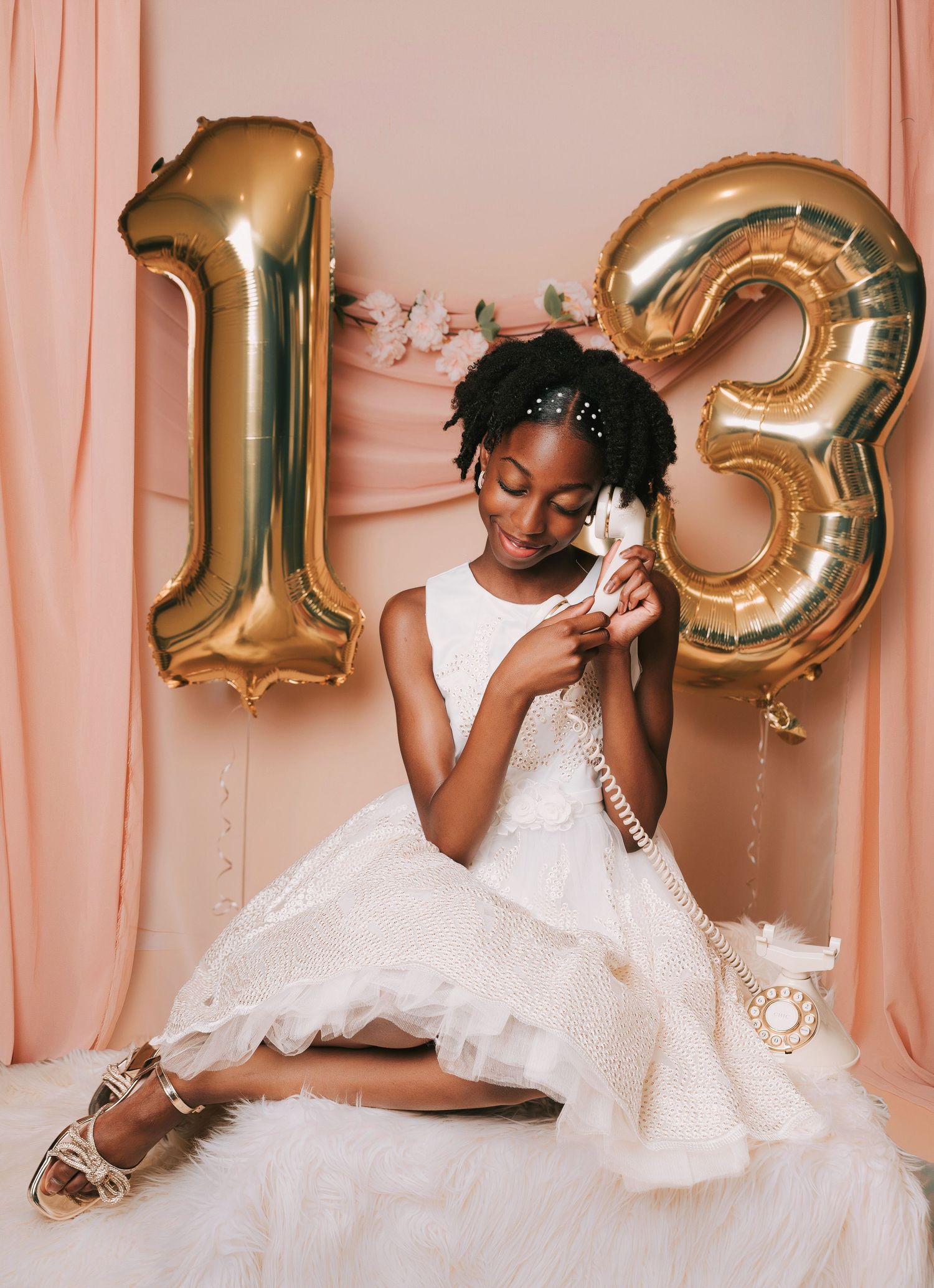A series of photos showing a young girl in a white dress posing against a pink backdrop with gold 13 number balloons.
