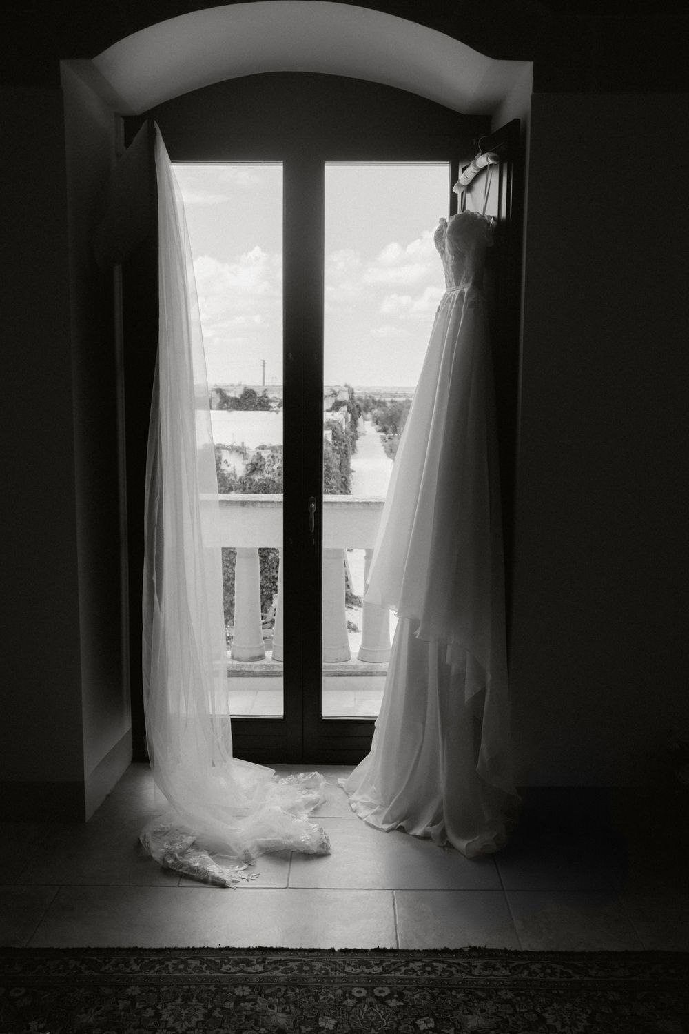 Ethereal white curtains billow softly beside dark window frames in a series of moody black and white photographs.