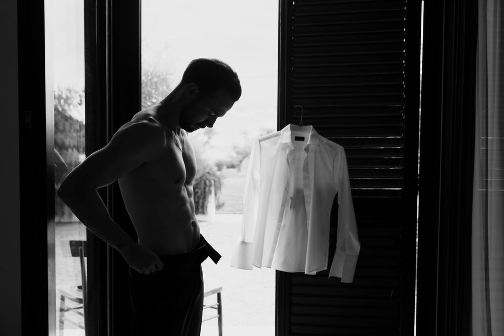 Black and white wedding photo showing a couple sharing an intimate moment in a doorway.