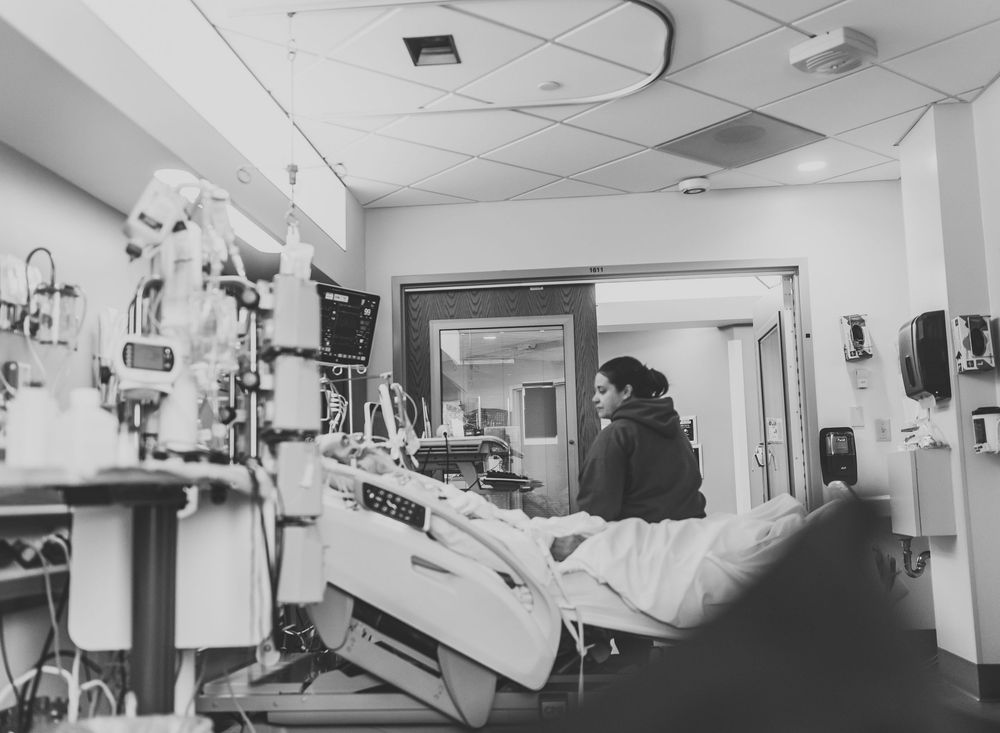 Black and white panoramic view of a medical examination room with hospital equipment and beds.