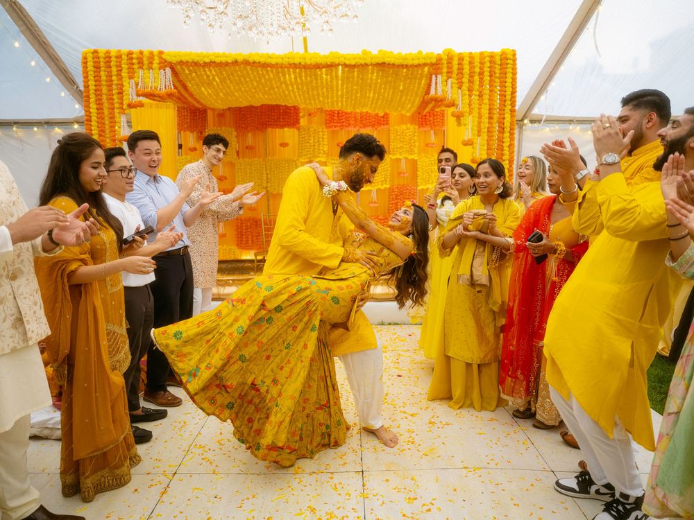 Traditional Indian wedding ceremony with yellow decor and guests participating in cultural rituals.