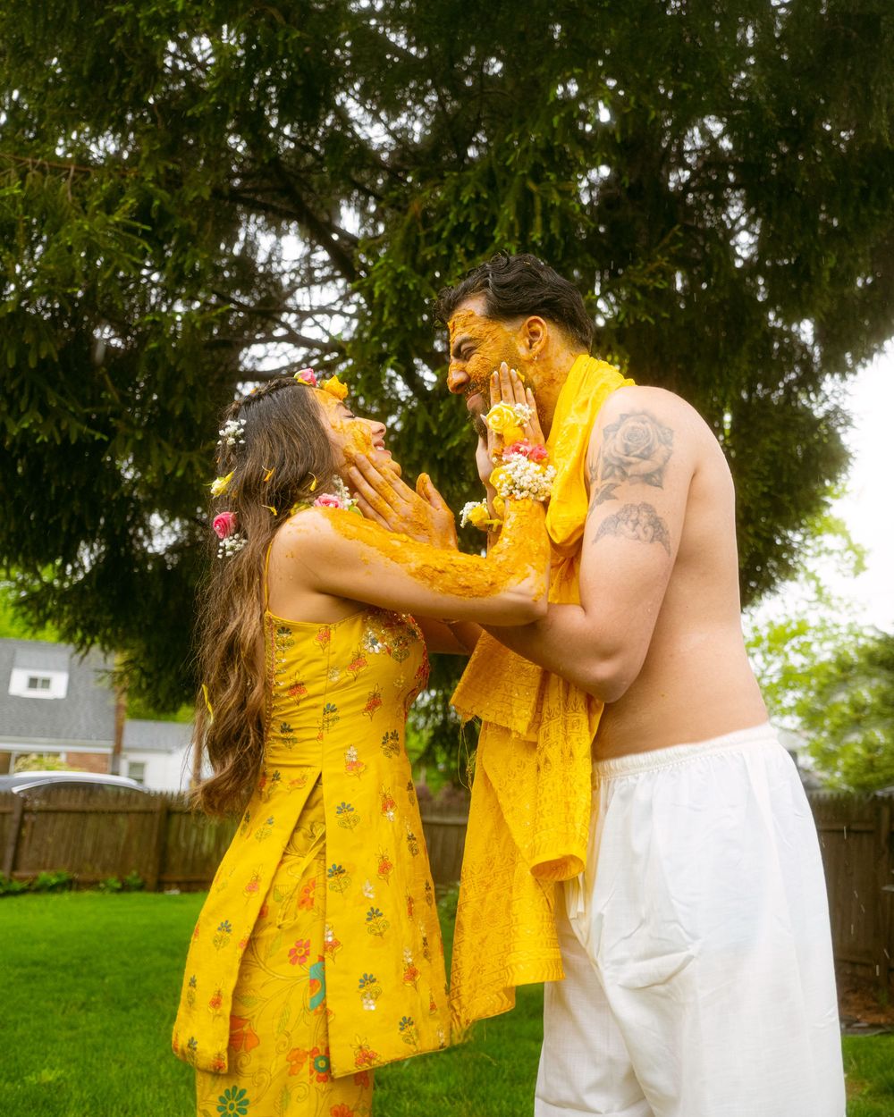 People in bright yellow floral dresses celebrate outdoors in a garden setting.