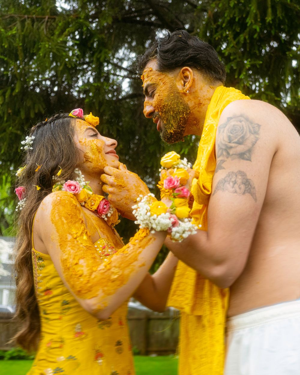 Two people in yellow dresses share an emotional embrace outdoors during a special occasion.