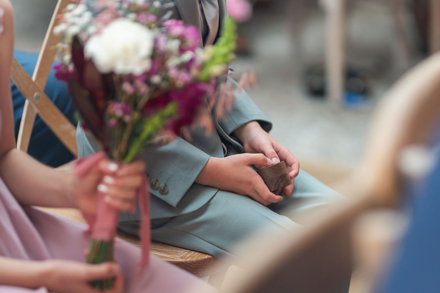 Close-up of hands holding colorful bouquets and floral arrangements at a flower market.