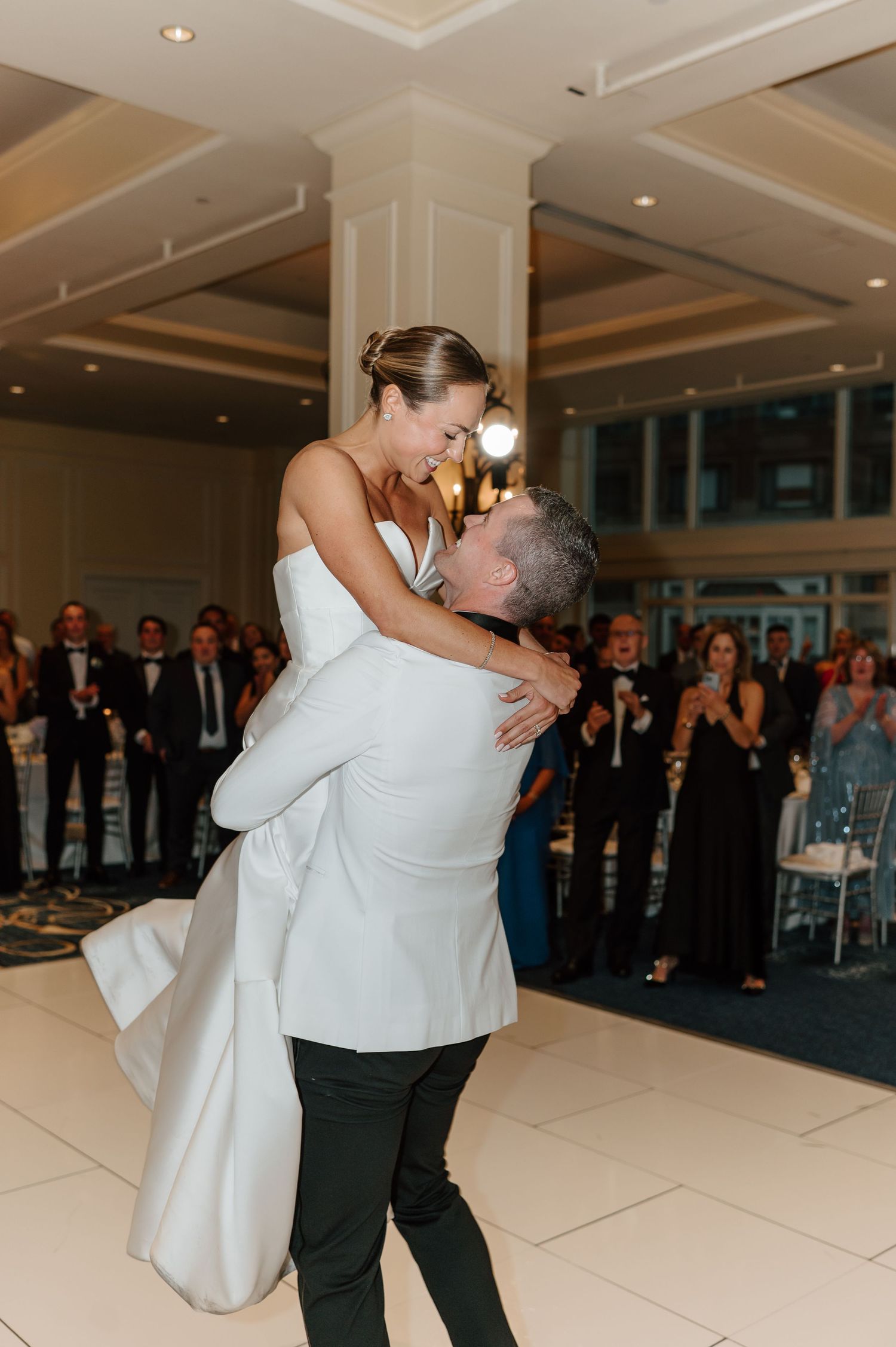 A romantic first dance sequence at a wedding reception shows a couple in white and black attire performing a dip on the dance floor.