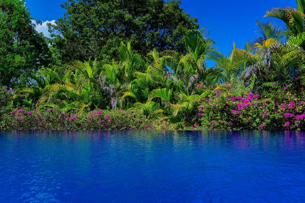 Sosua villa for buying with 2 dining areas, poolside BBQ, and midnight blue infinity pool.