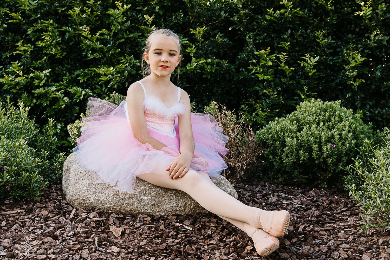 girl sitting on a rock in playground in dance costume