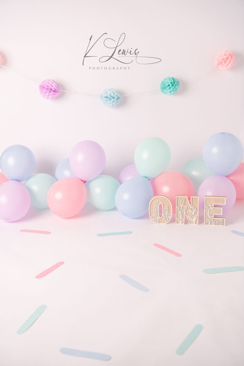 Pastel balloon garland with ONE sign for a first birthday cake smash photography backdrop.