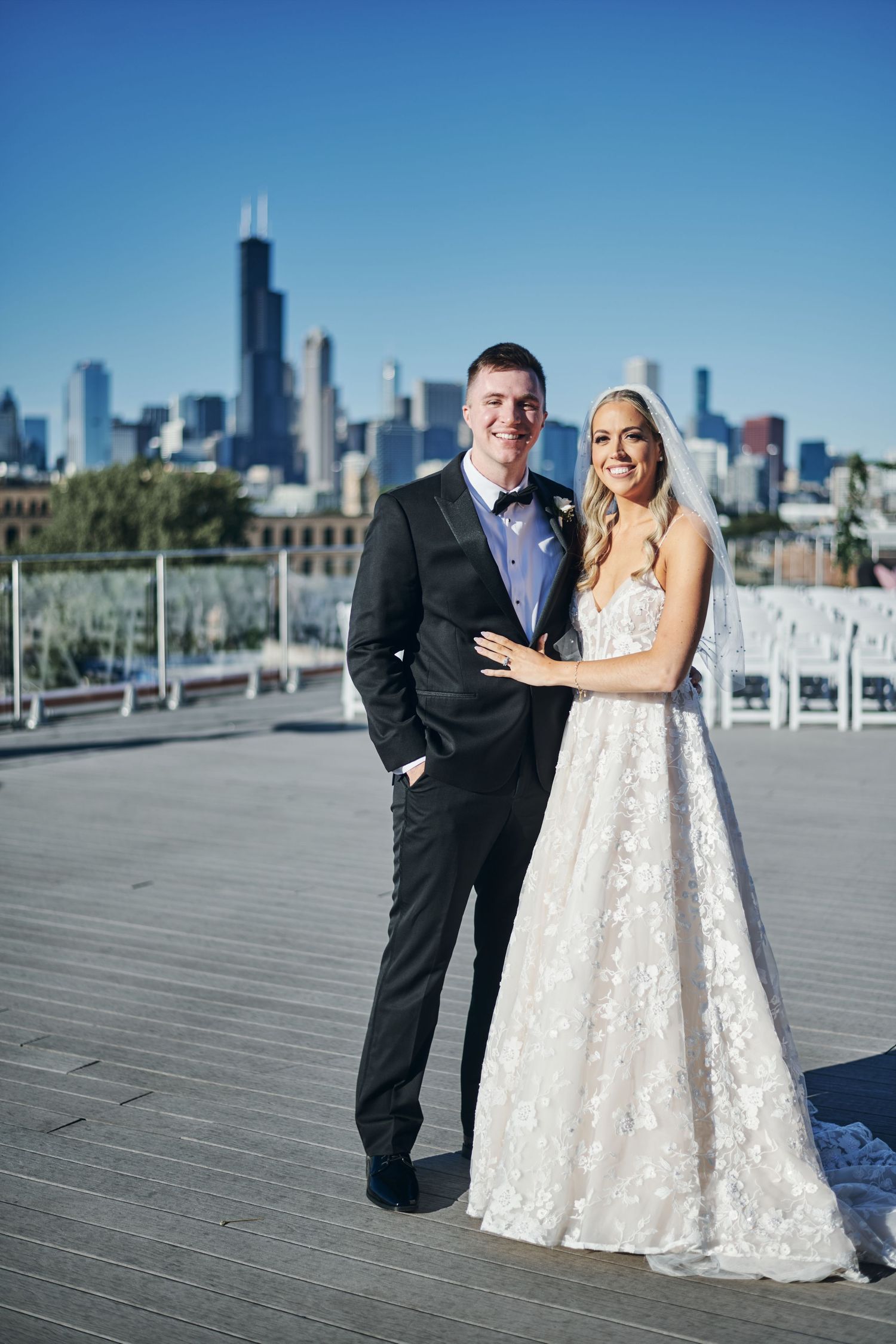 A romantic black and white photo series of a couple on a boardwalk with the Chicago skyline in the background.